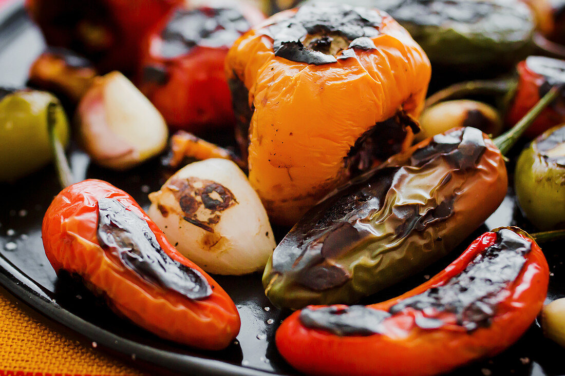 Roasted vegetables placed on black tray in kitchen