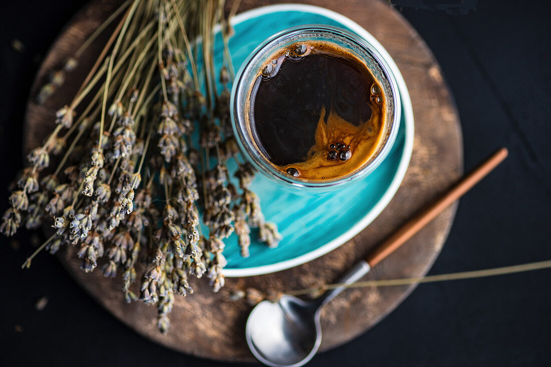 A glass of coffee with dried lavender flowers