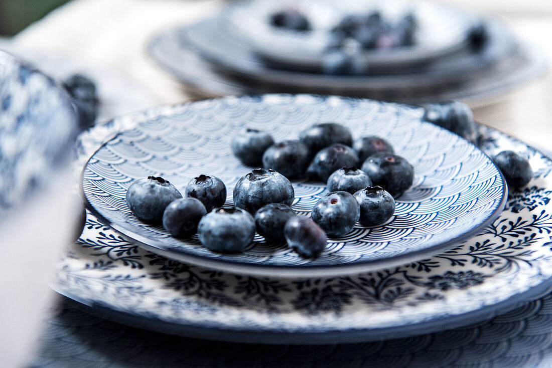 Blaubeeren auf blau-weißem Geschirr (Nahaufnahme)