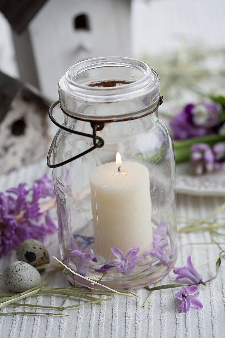 Kerze im Einmachglas mit Hyazinthen und Wachteleiern