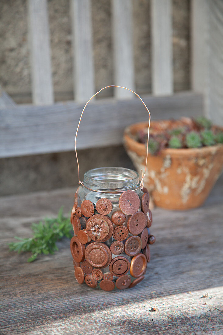 Candle lantern made from screw-top jar and buttons painted rust-red