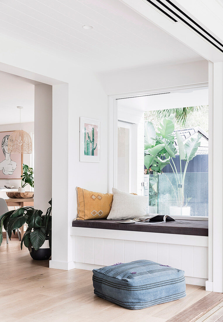 Built-in bench with cushions in front of the window