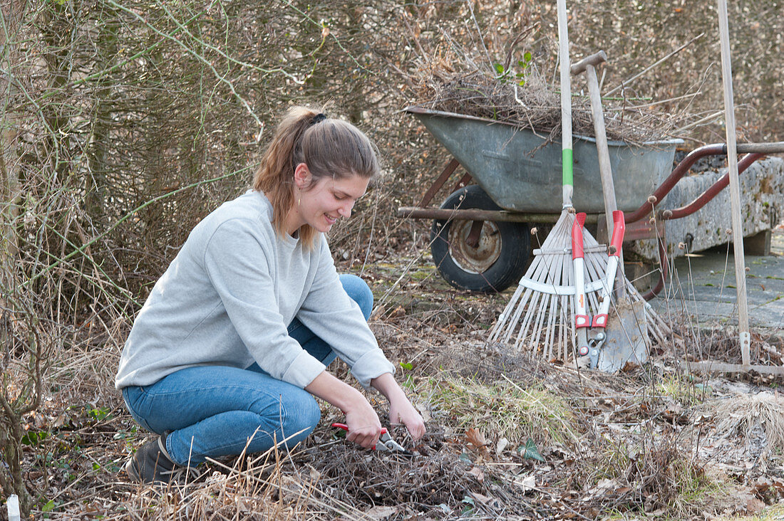 Woman doing spring cleaning in the garden