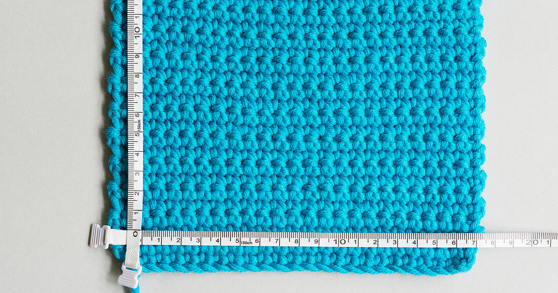 A crocheted gauge with a measuring tape