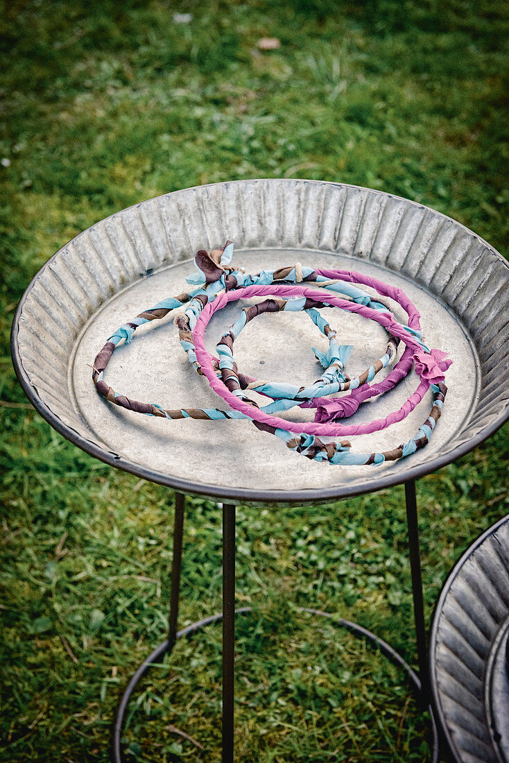 Rings wrapped with fabric for game of quoits in metal dish