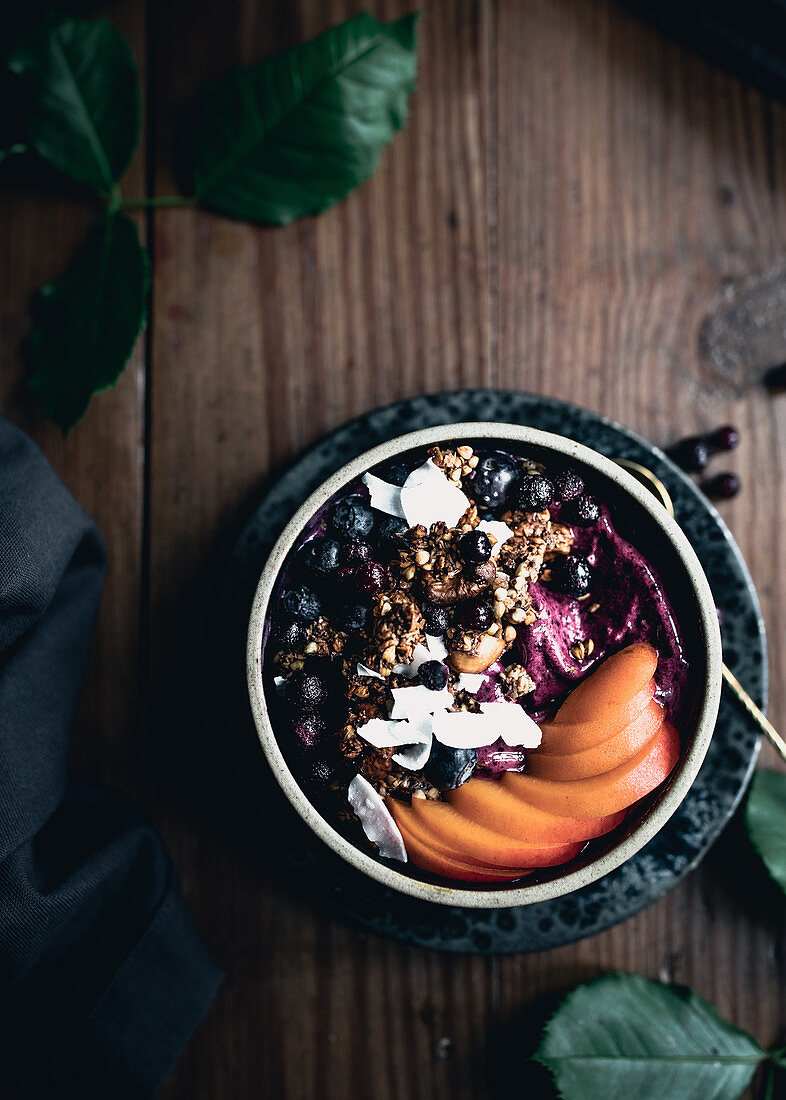 Acai bowl with fresh apricots, berries and coconut chips
