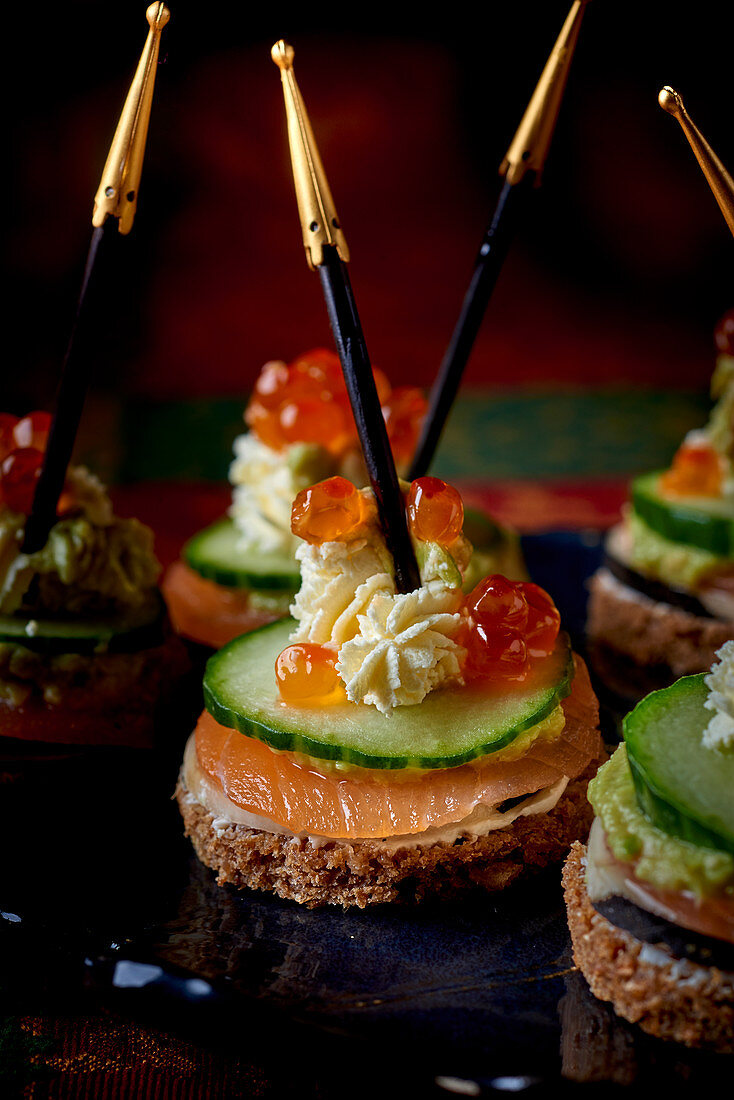 Black bread canapés with cucumber and salmon caviar