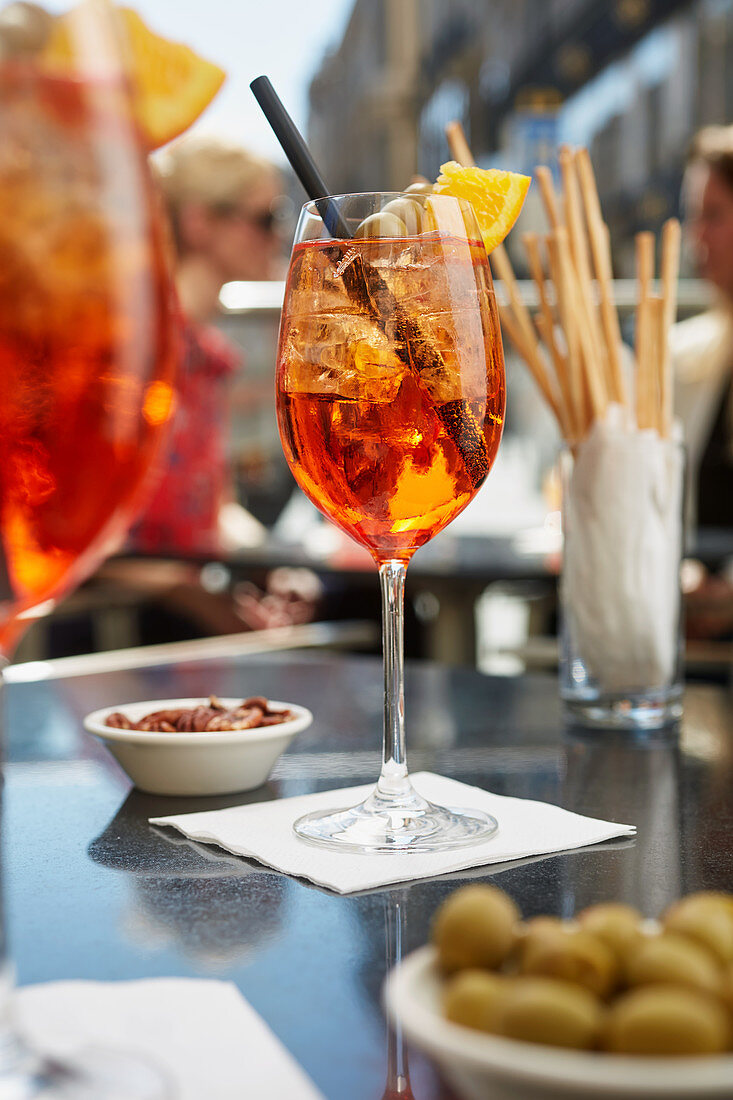 Aperol Spritz, olives, almonds and grissini in a restaurant