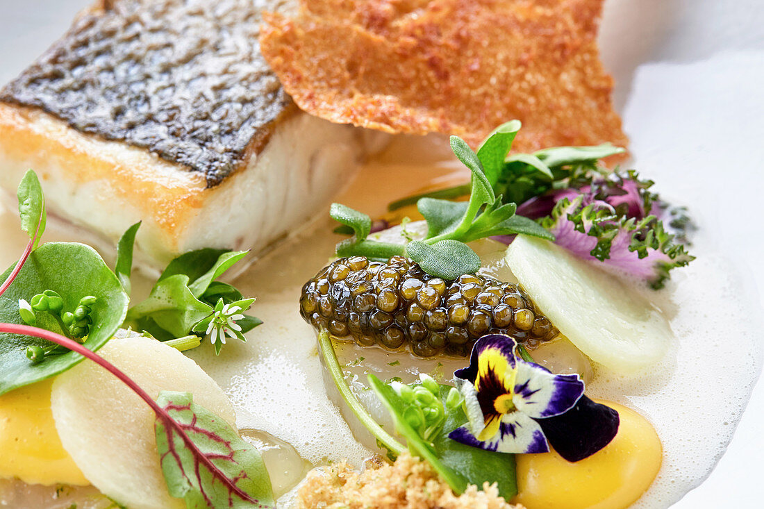 Wolfsbarsch mit Kaviar, Gemüse und Essblüten