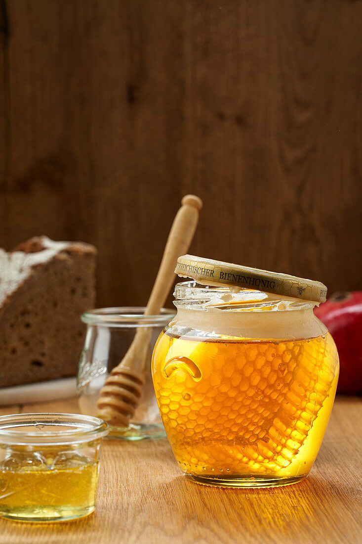jar of honey with honeycomb in ray of sunlight