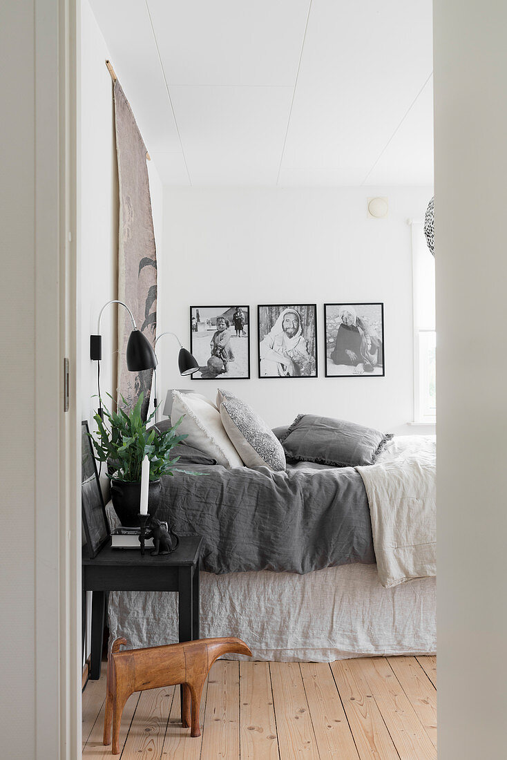 Blick ins Schlafzimmer in gedeckten Farben mit Dielenboden