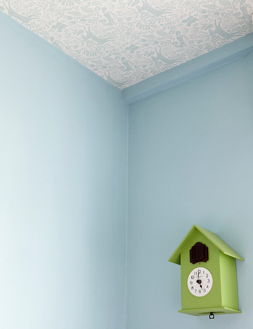 Ceiling papered with blue-and-white patterned wallpaper in corner of room with blue walls