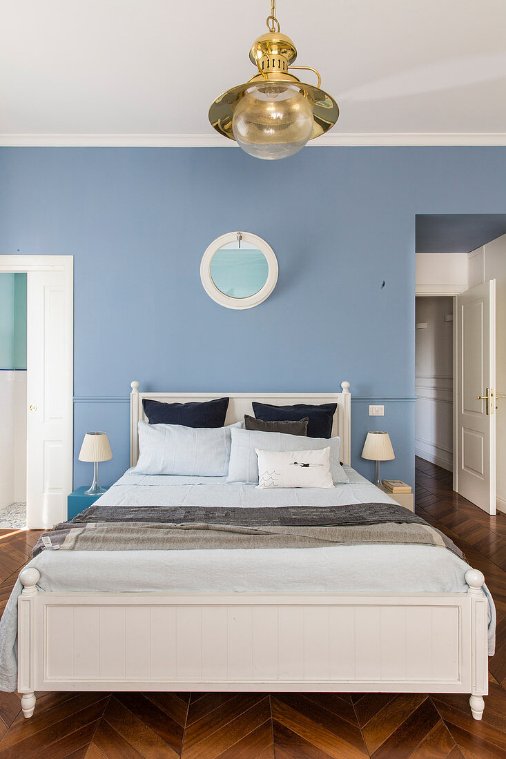 Bedroom with pale blue wall and herringbone parquet floor in period building