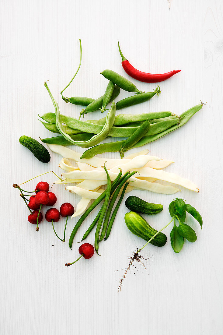 An arrangement of beans, peas, cucumber, chilli and cherries