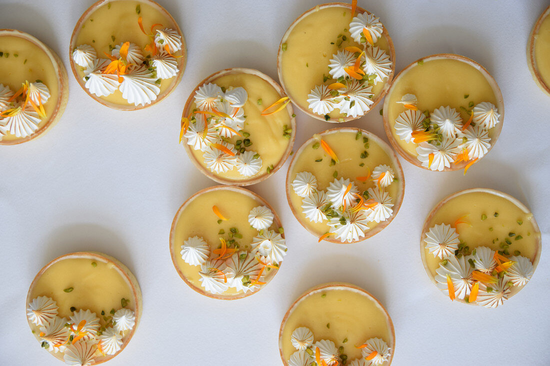 Lemon and passion fruit cakes with meringue dots and flower petals