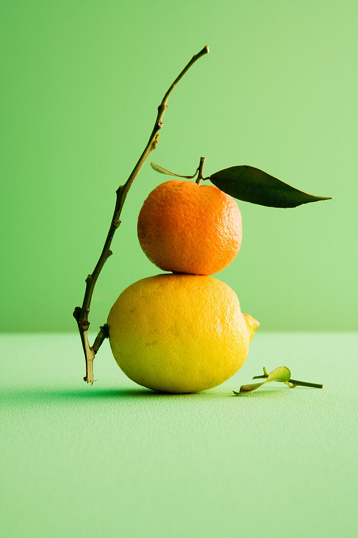 An orange on top of a lemon