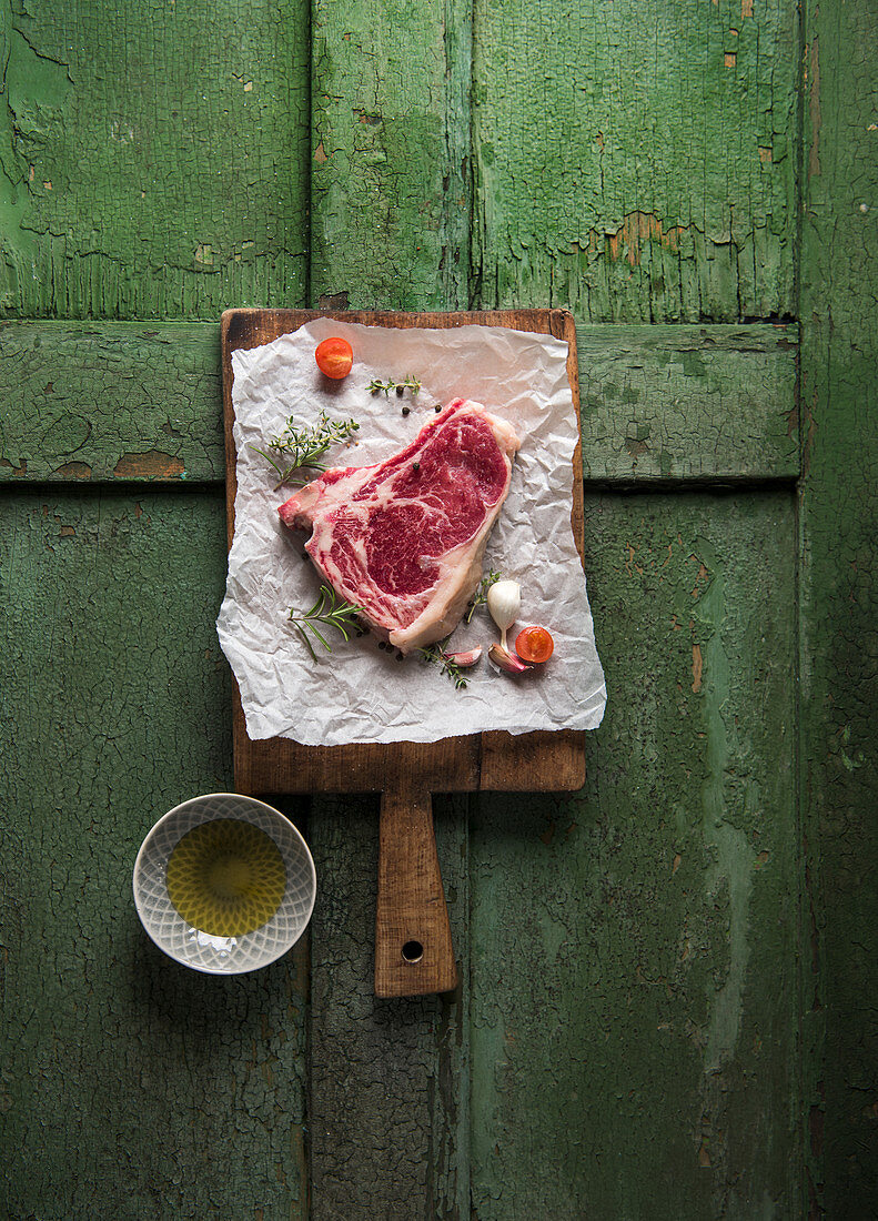 A raw club steak on a chopping board