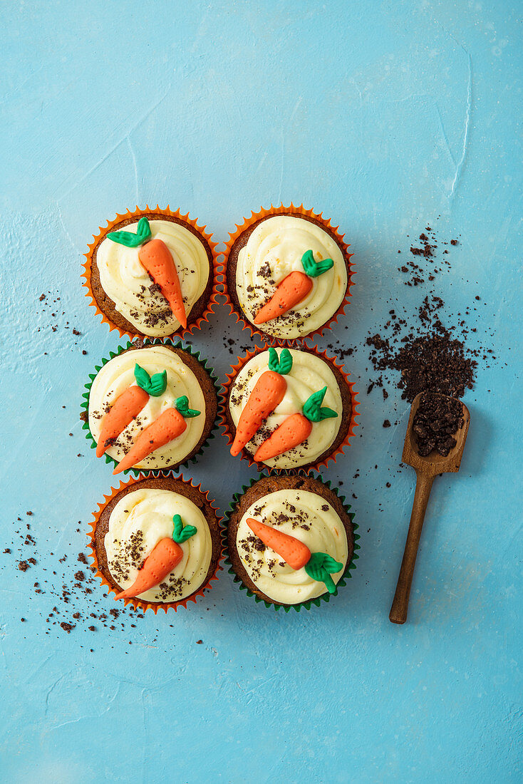 Carrot cake cupcakes with orange cream cheese icing and crushed biscuits