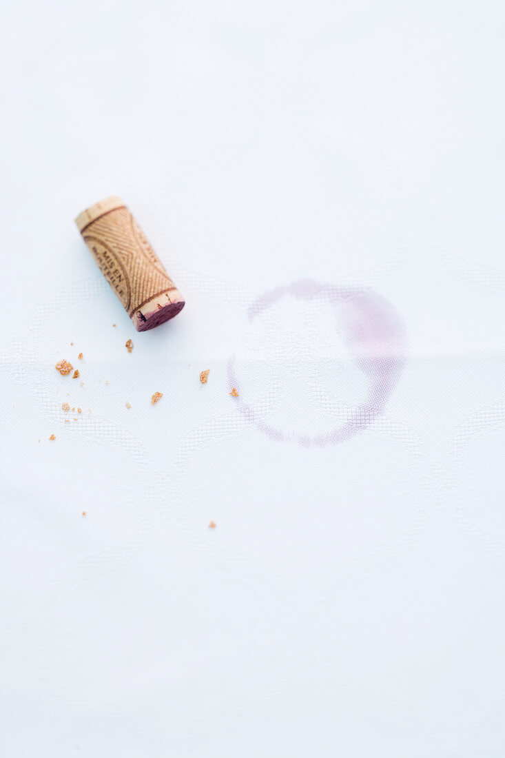 A cork from a red wine bottle on a piece of white paper