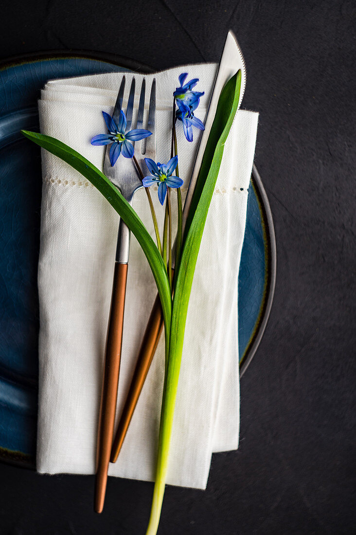 Festive table setting with scilla flowers for Easter holiday dinner
