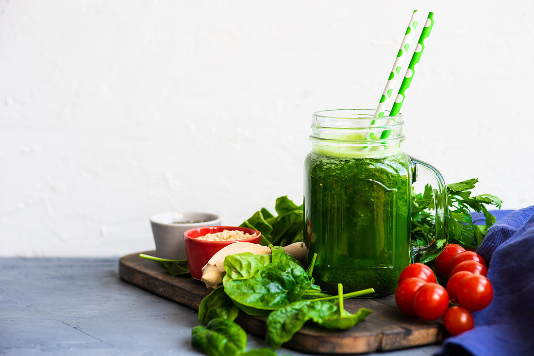 Green smoothie of apple, baby spinacj, cucumber, chia seeds on concrete background