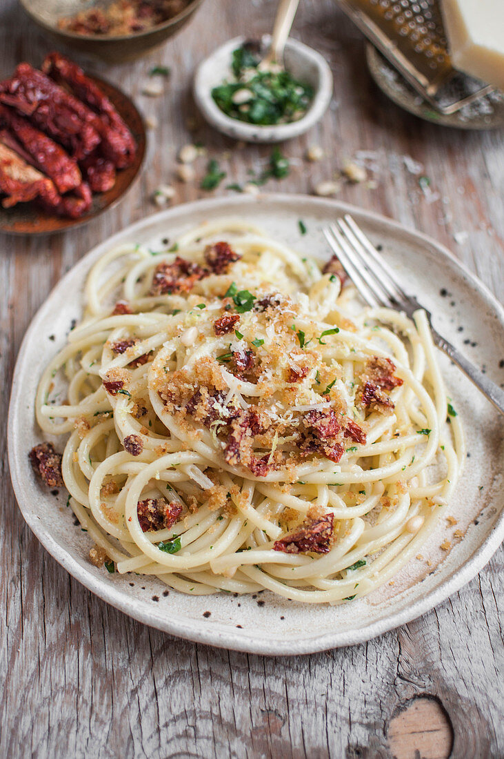 Bucatini pasta with sun dried tomatoes, parsley, parmesan cheese, pine nuts and pangrattato