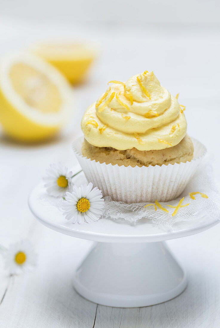 A lemon muffins with frosting on a mini cake stand