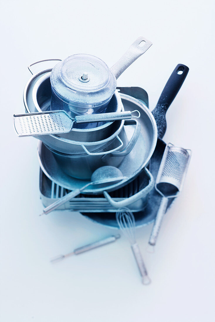 A stack of pots and pans and cooking utensils