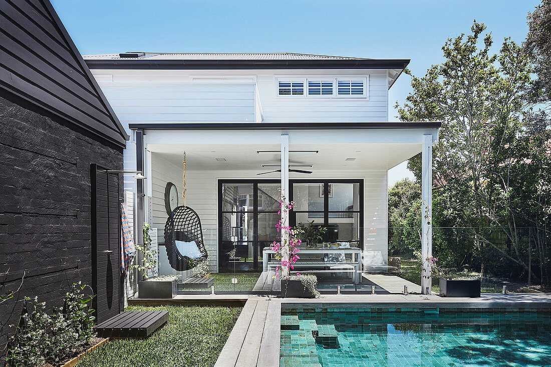 Garten mit Pool hinterm Haus mit überdachter Terrasse