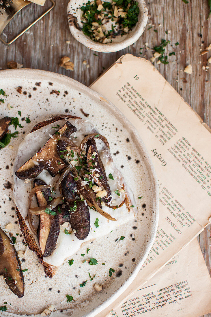 Toast with goat cheese and wild mushrooms topped with chopped parsley and nuts