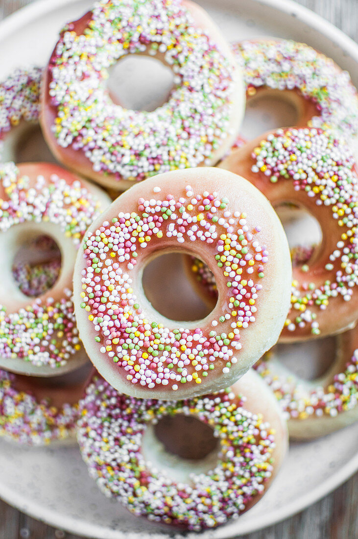 Vegan doughnuts topped with icing and colorful sprinkles
