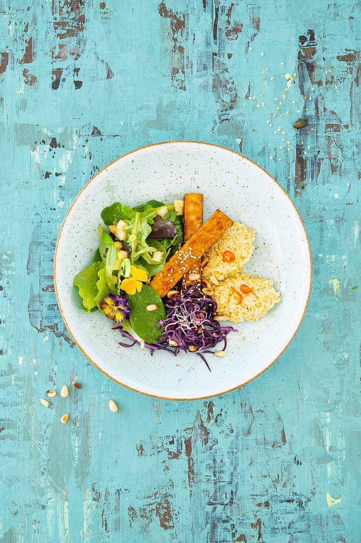 Coconut millet with tempeh, red coleslaw and salad with a pear dressing
