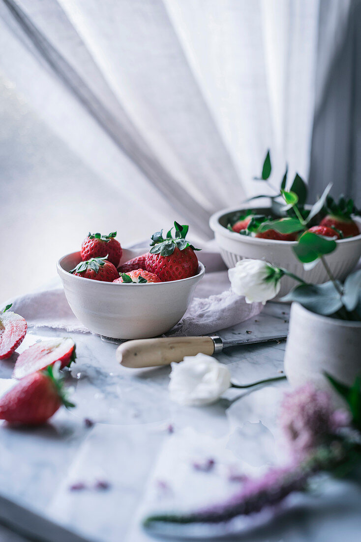 Erdbeeren und Blumen auf Marmortisch