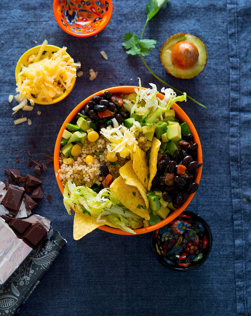 A bowl with beans, avocado, nachos, quinoa, cheese and chocolate (Mexico)
