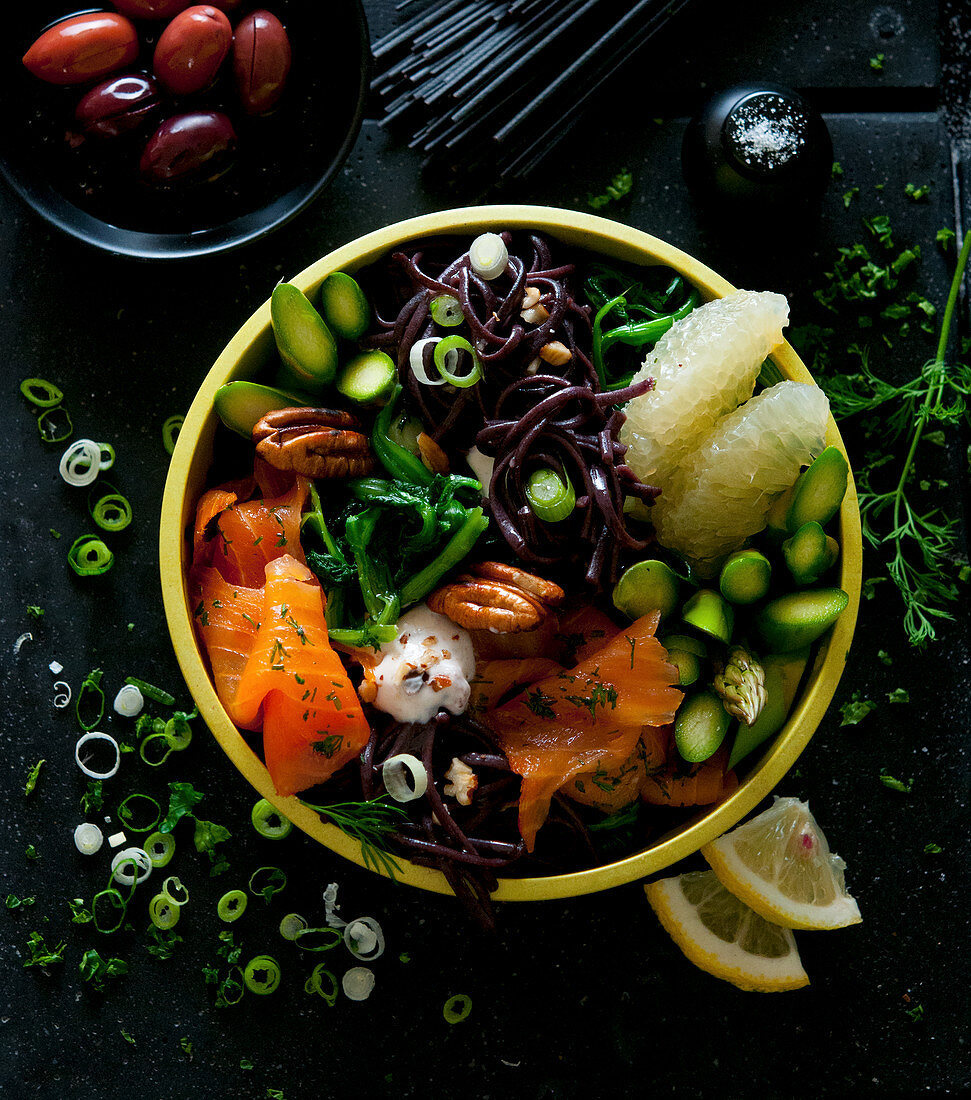 Bowl mit Lachs, schwarzen Nudeln, Spargel, Grapefruit und Olivencreme