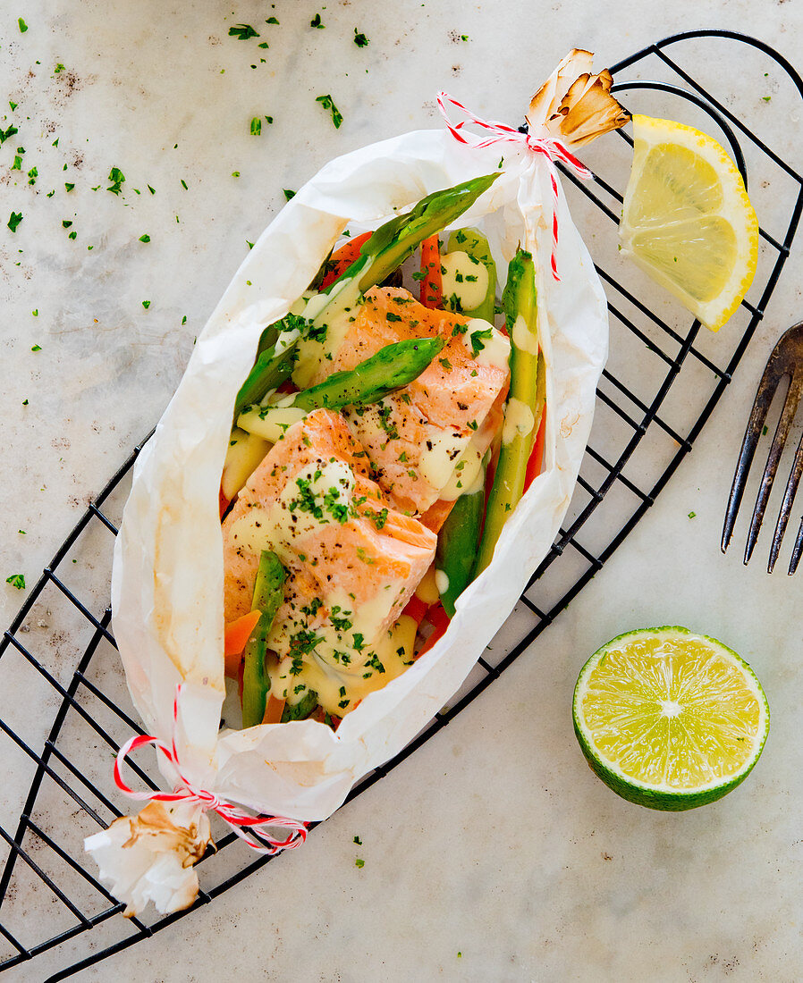 A salmon parcel with green asparagus and carrots