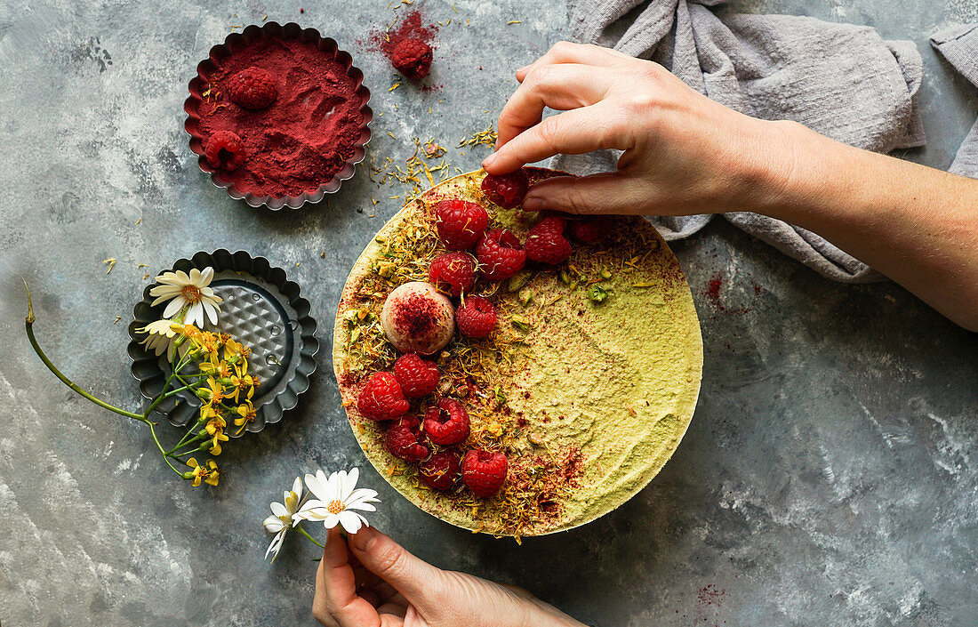 Vegan raw cashew cake with berries, coconut butter and coconut milk, and base made of almonds, dates