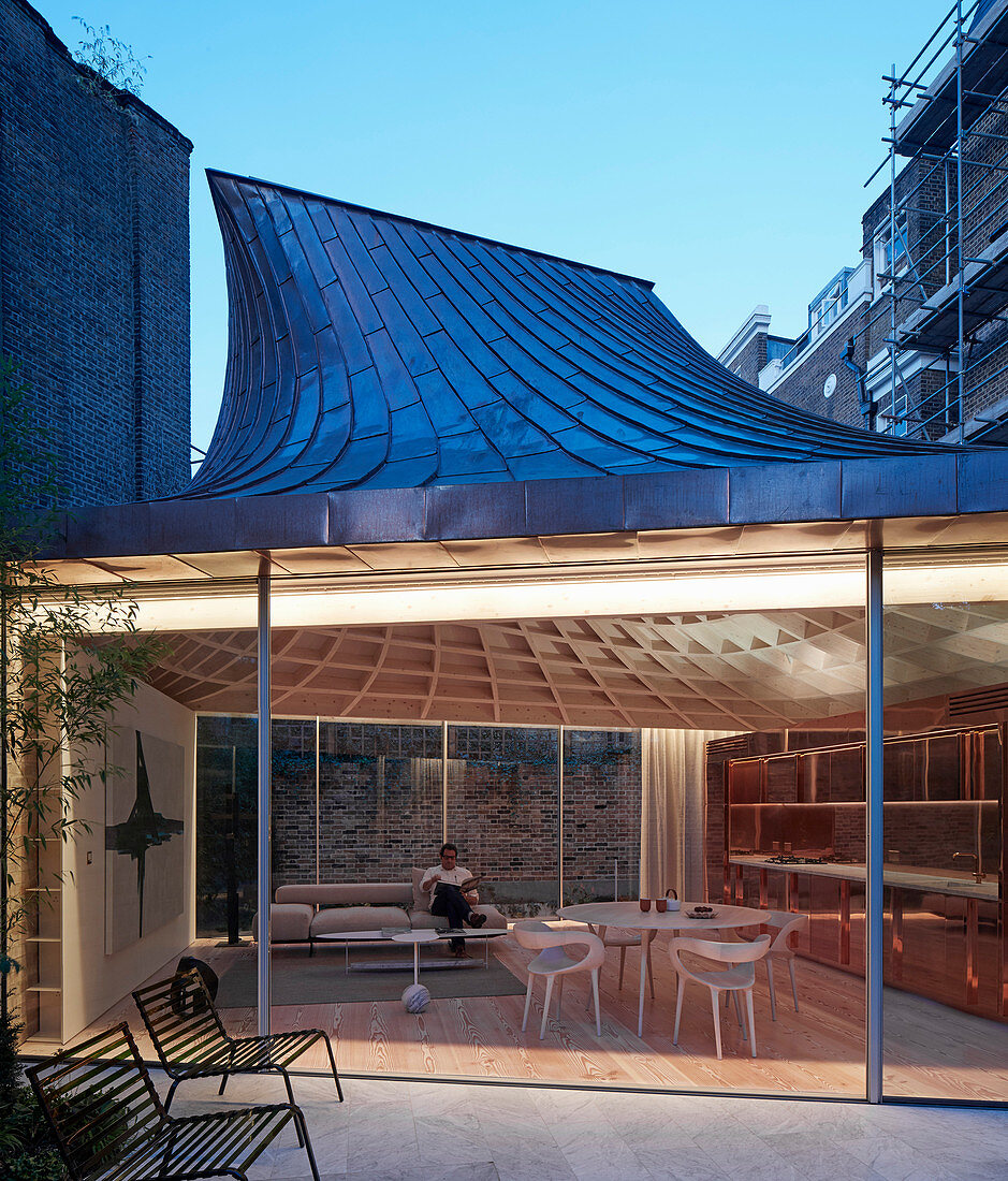 Modern extension with glass walls and funnel-shaped roof