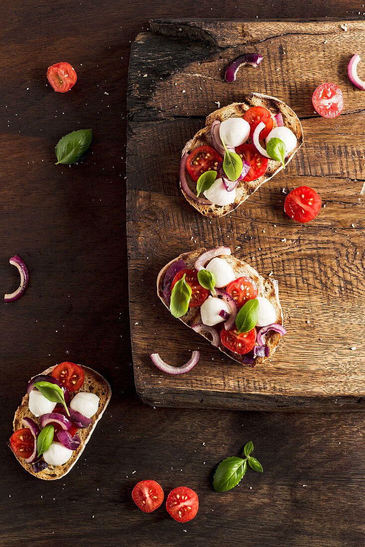 Bruschetta mit Mozzarella, roter Zwiebel, Erdbeertomaten und Basilikum