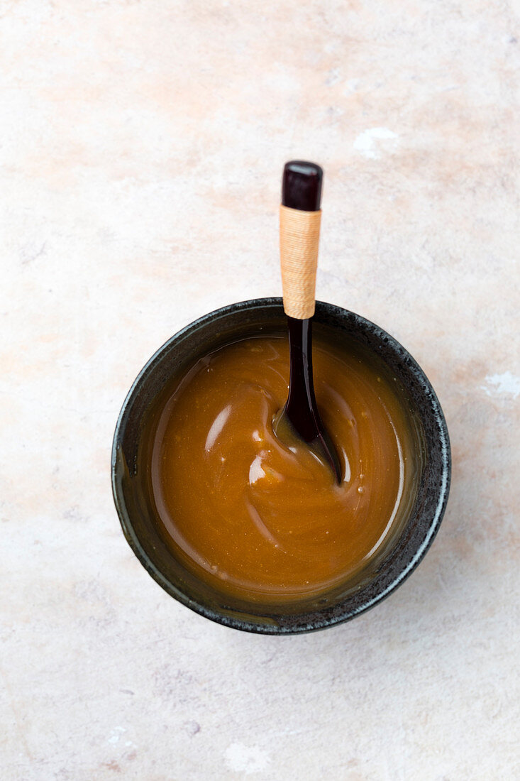 Caramel sauce in a bowl with a spoon