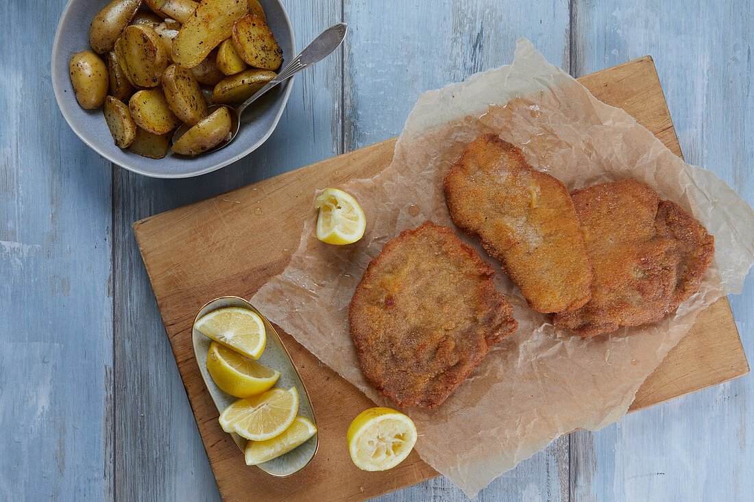 Schnitzel with lemons and fried potatoes