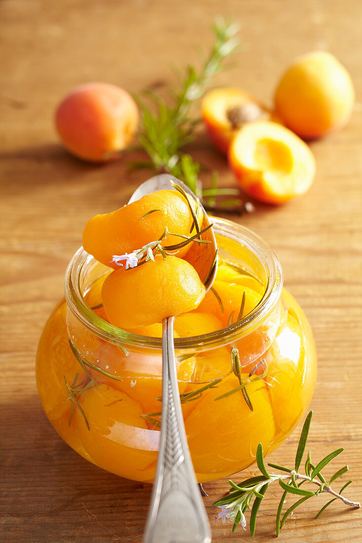Preserved apricots with fresh rosemary in a preserving jar