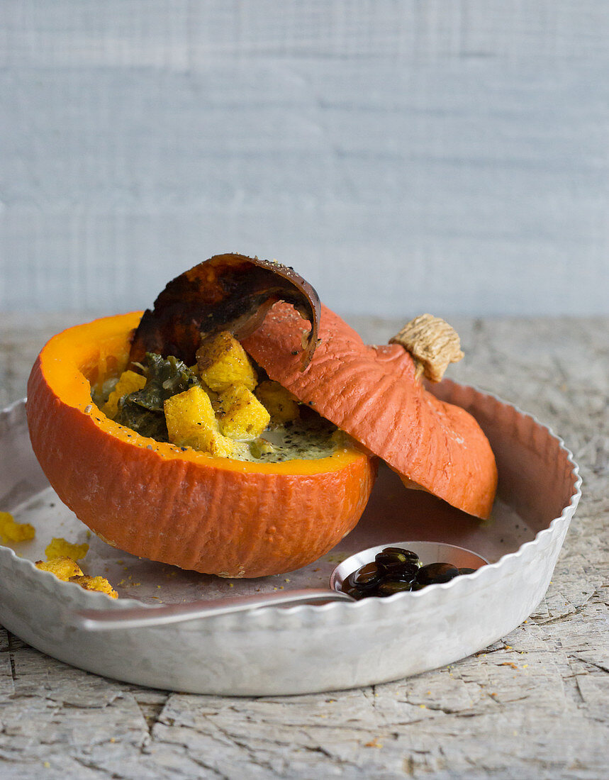 Pumpkin, filled with kale soup and pumpkin bread croutons