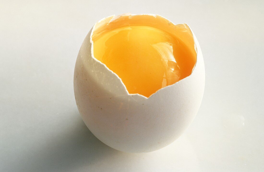 Ein geköpftes rohes Ei mit Eigelb