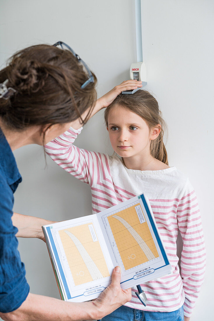 Doctor measuring the height of a young girl