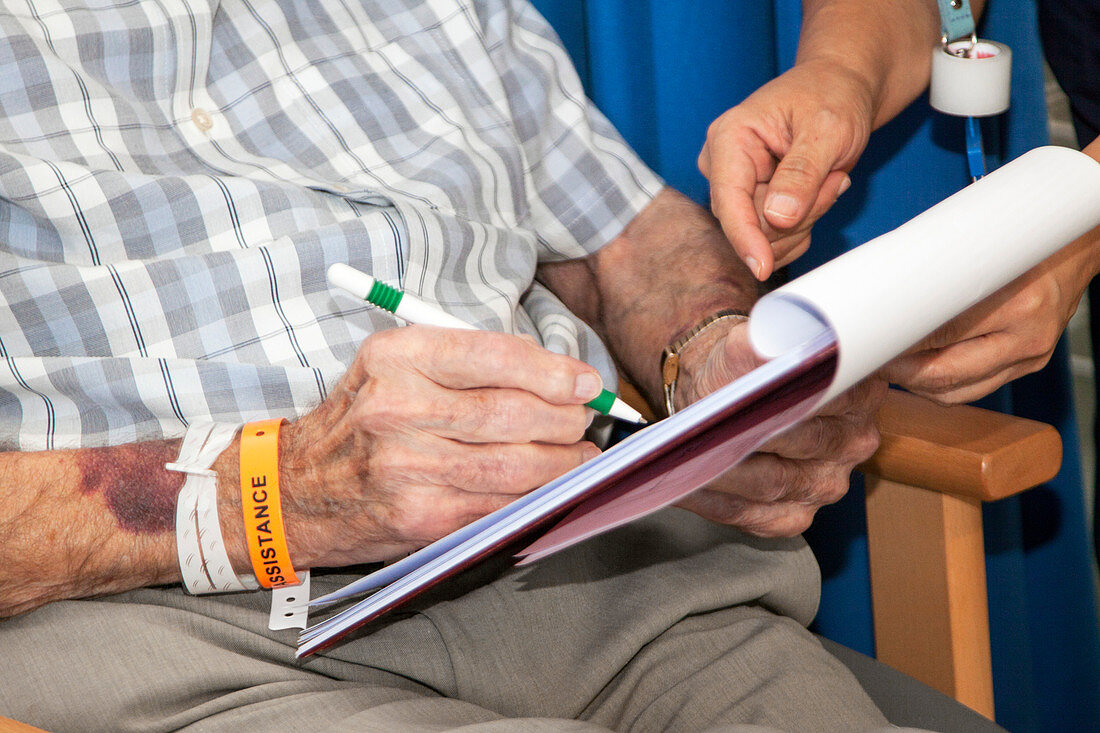 Consent form being signed by an elderly patient