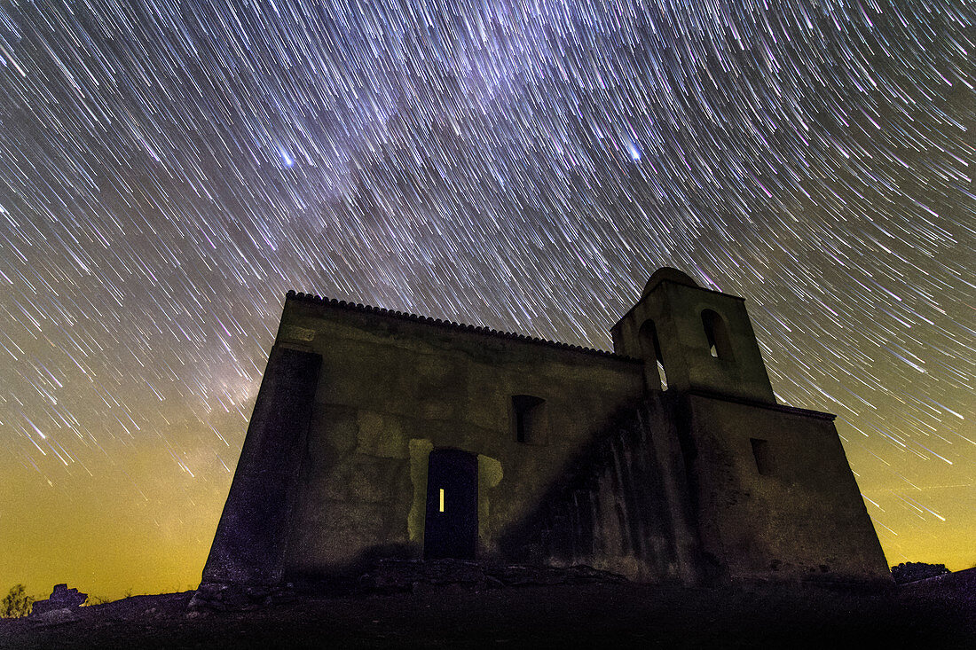 Star trails over Noudar Castle's church, time-exposure image