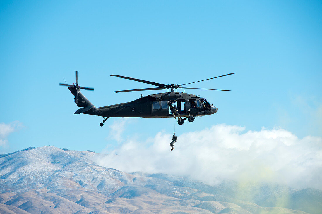 Soldier rappelling out of Black Hawk helicopter