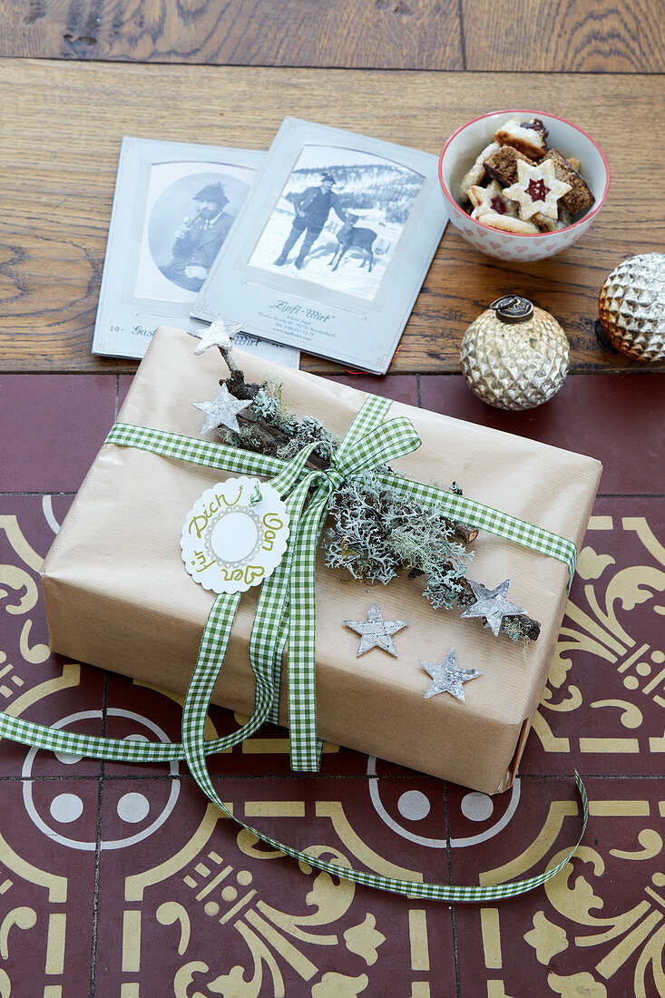 Rustikal verpacktes Geschenk mit Siegelwachs und Zweig mit Flechten