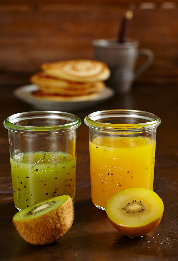 Selbstgemachter gelber und grüner Kiwi-Sirup in Gläsern